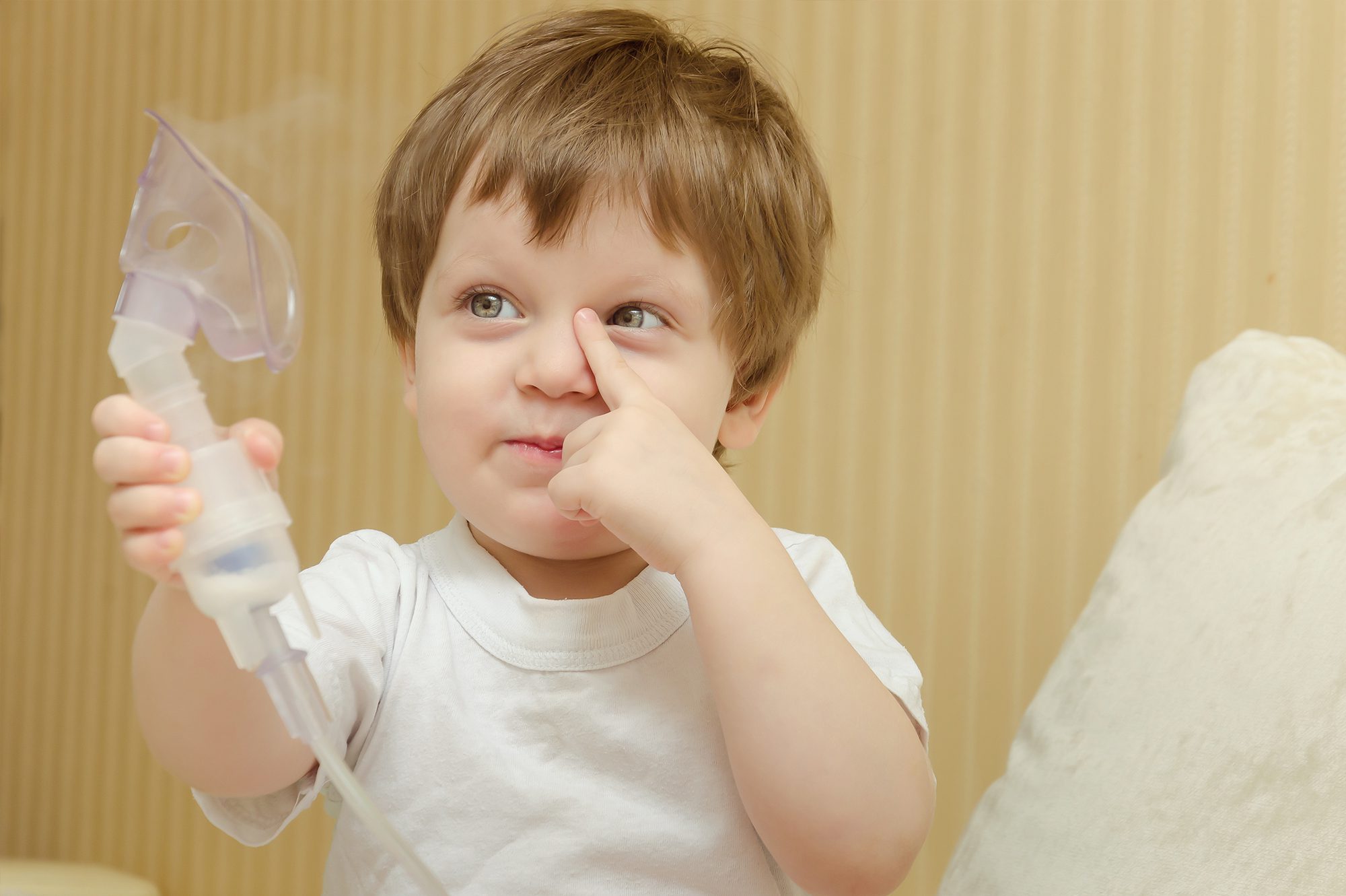 Little boy holding a sedation nitrous gas mask.
